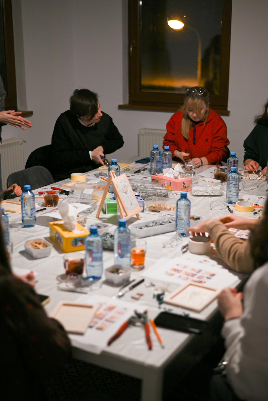 People creating mosaic art together in a workshop setting